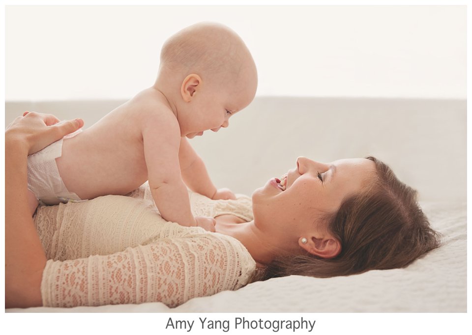 Mom and baby sharing a joyful moment during a Charlottesville newborn photography in-home session.
