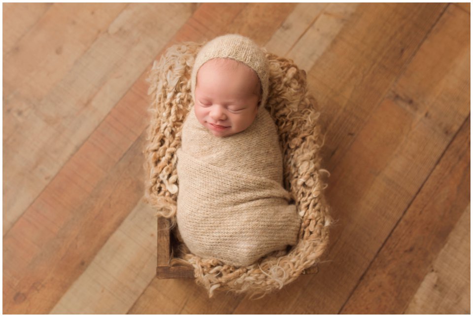 Sleeping newborn in a wooden crate for sibling newborn photos in Charlottesville, VA.