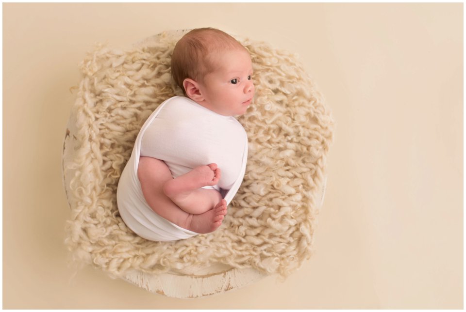Newborn baby wrapped in white for sibling newborn photos in newborn studio at Charlottesville, VA.