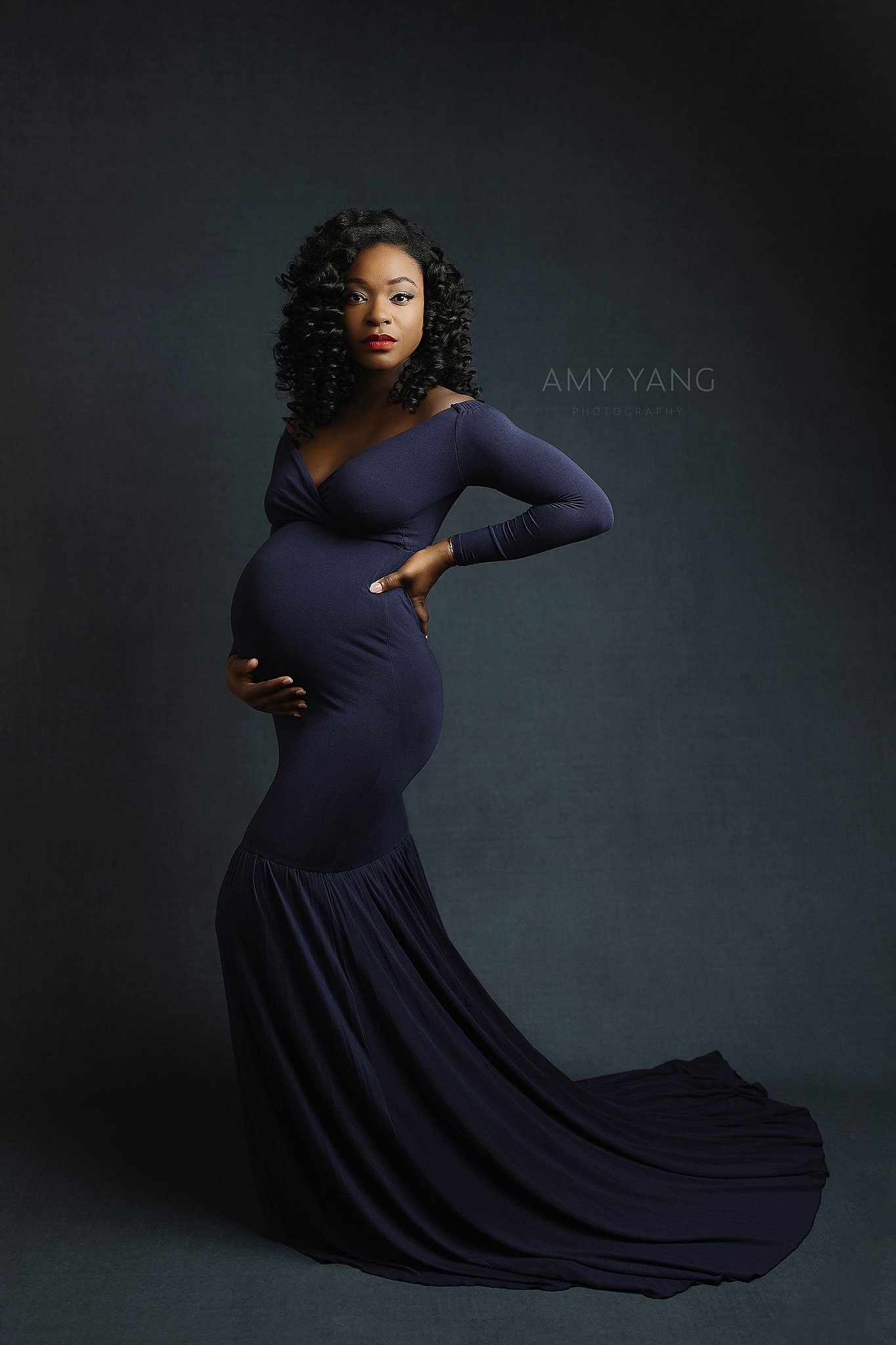 mother-to-be holds her belly and her back during maternity session