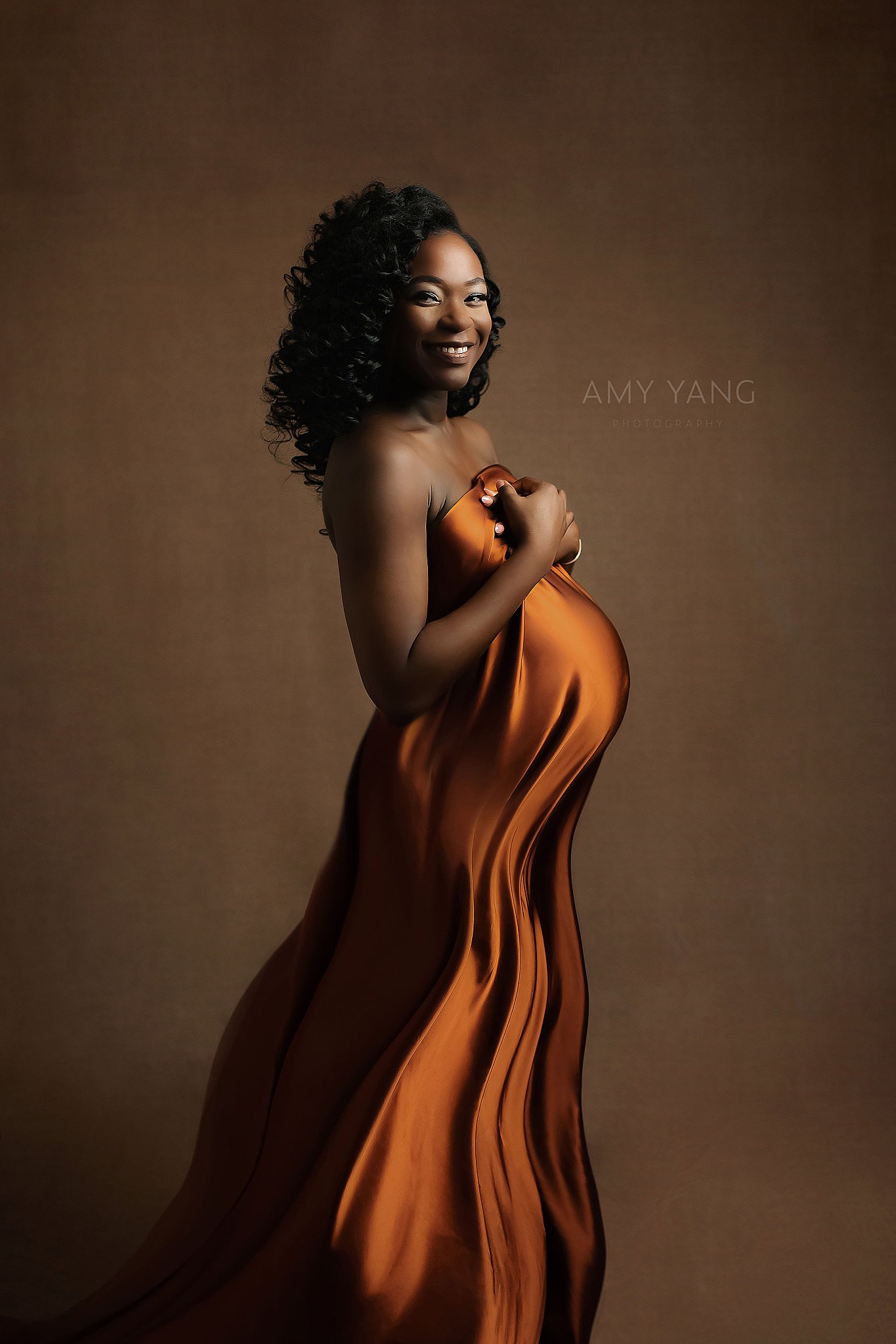 bronze satin covers pregnant mama's body as she smiles by Amy Yang Photography