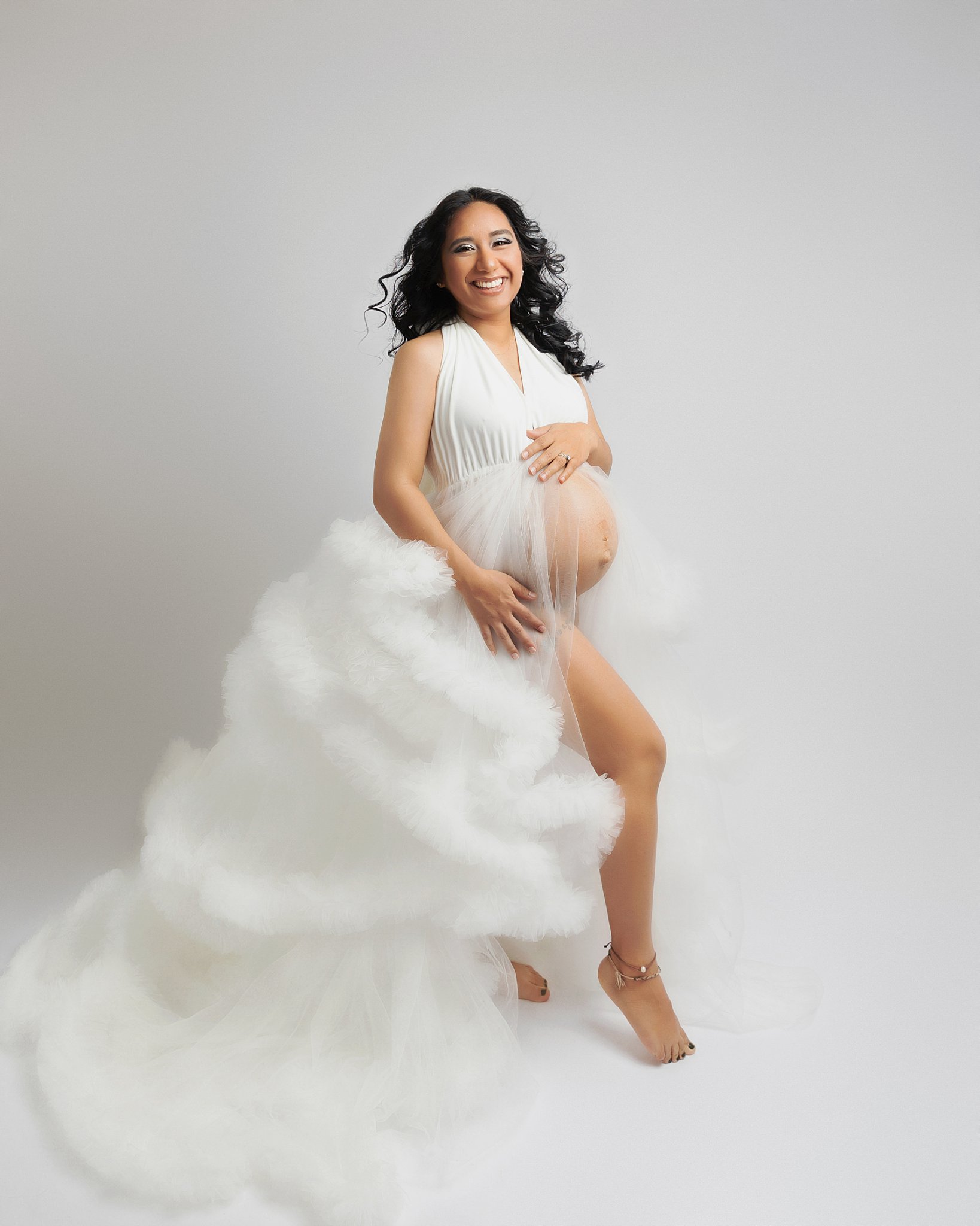 radiating mom-to-be smiles as she holds her belly by Charlottesville photographer