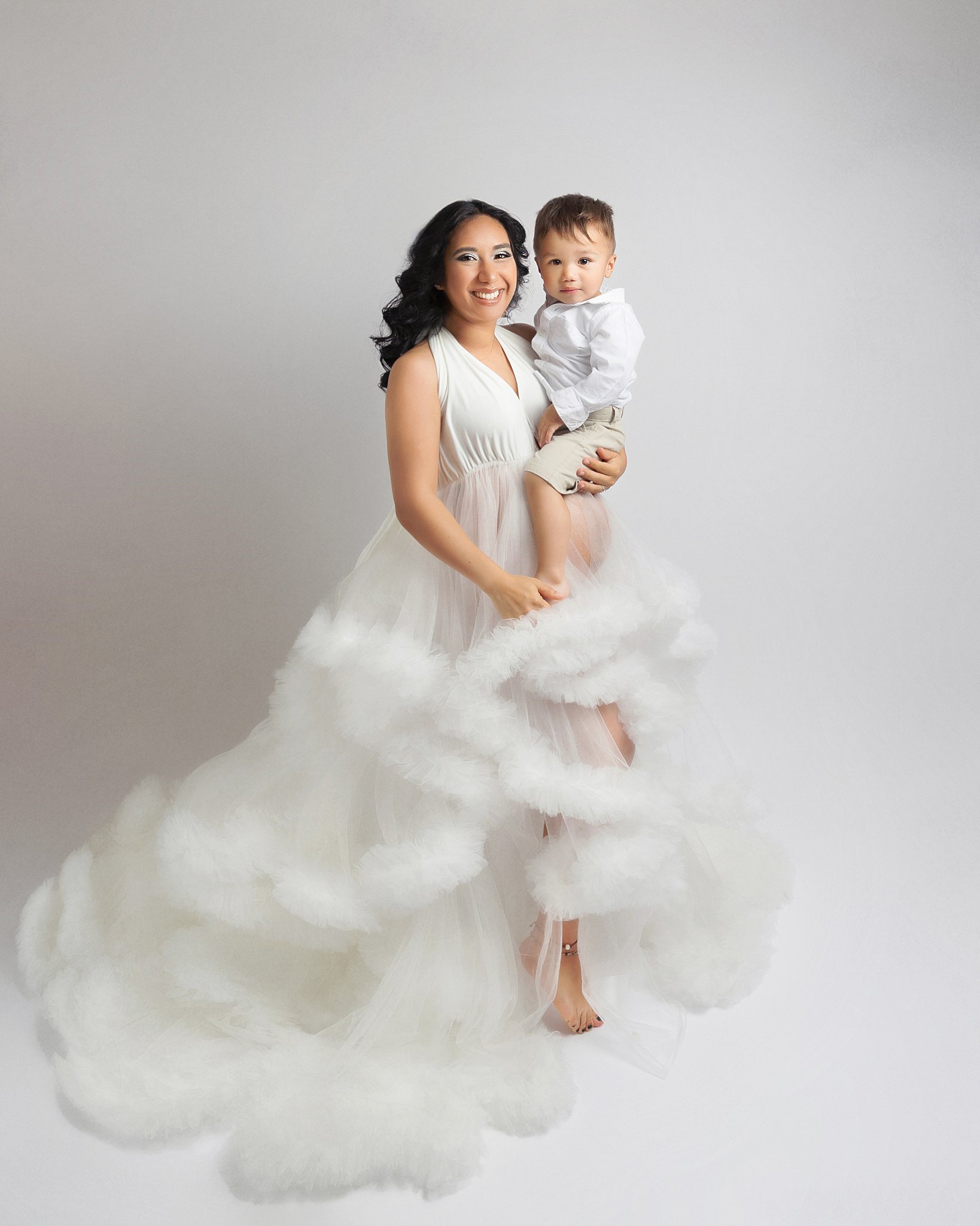 woman holds son during studio maternity session