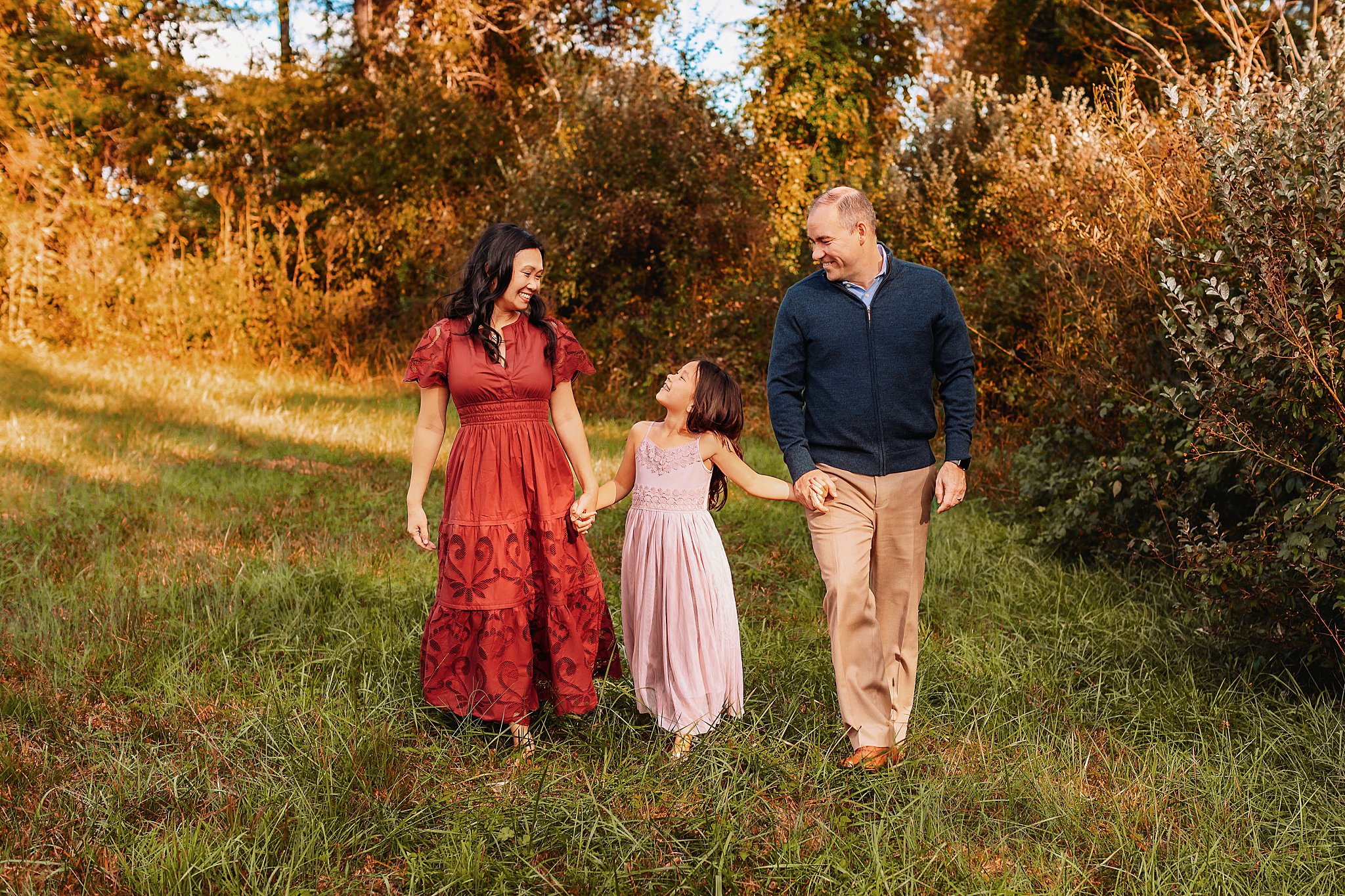 mom and dad hold hands with child by Charlottesville photographer