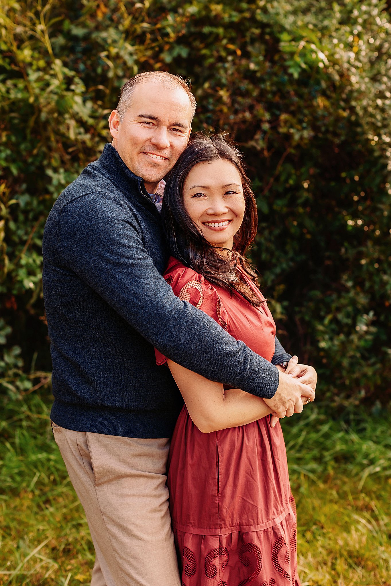 couple smiles together with arms wrapped around each other by Amy Yang Photography