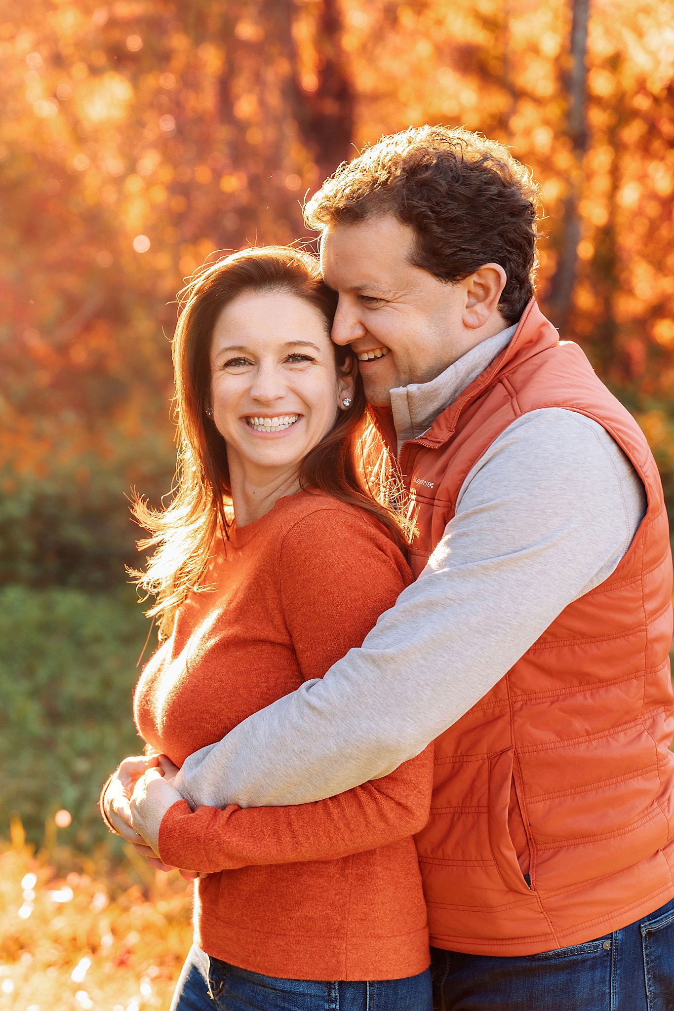 man wraps his arms around his wife from behind as they both smile by Amy Yang Photography