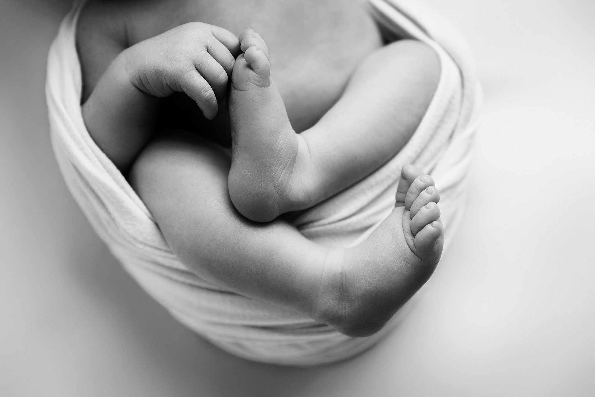 baby toes stick out of wrap during newborn studio session