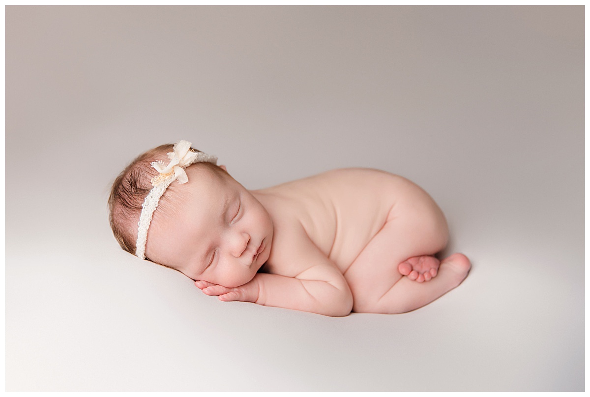 baby wears just a headband during fine art newborn studio session