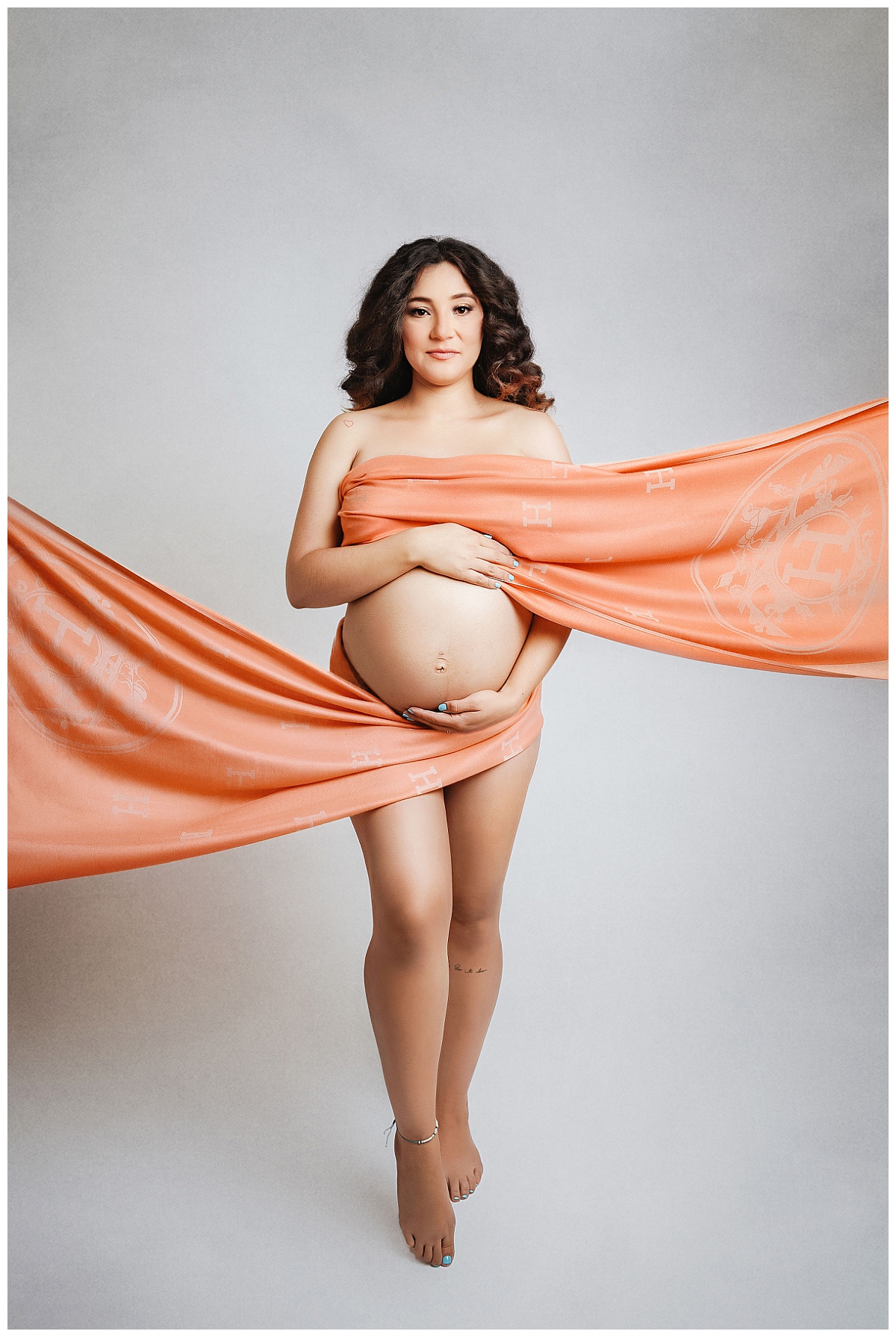mom-to-be wrapped in Hermes for luxe studio maternity session