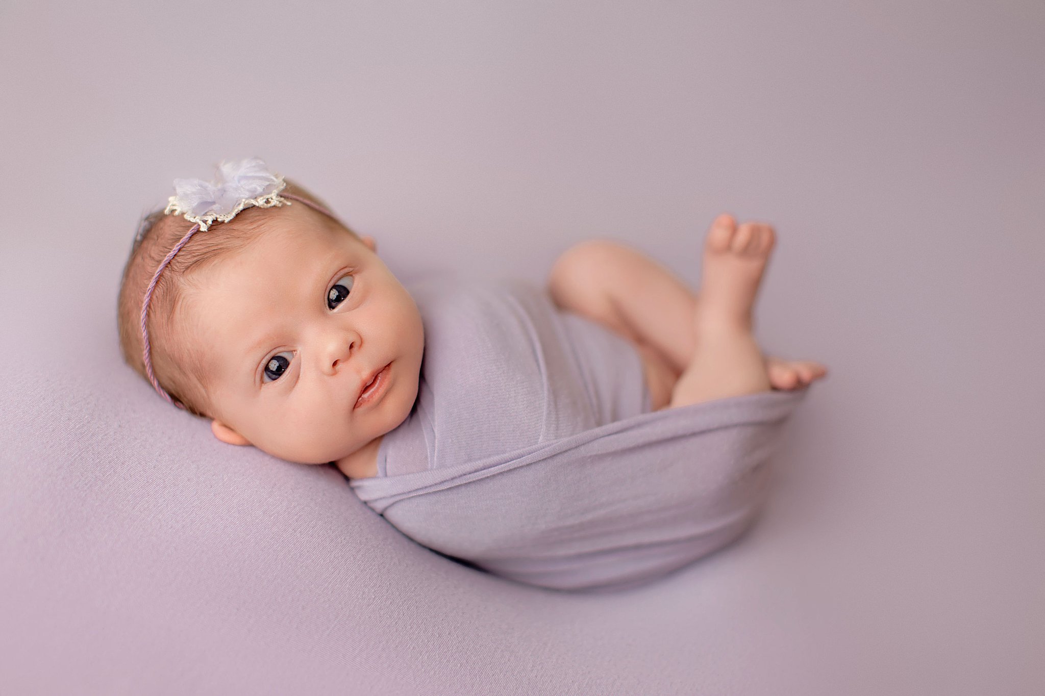 baby girl swaddled in purple during sweet newborn studio session