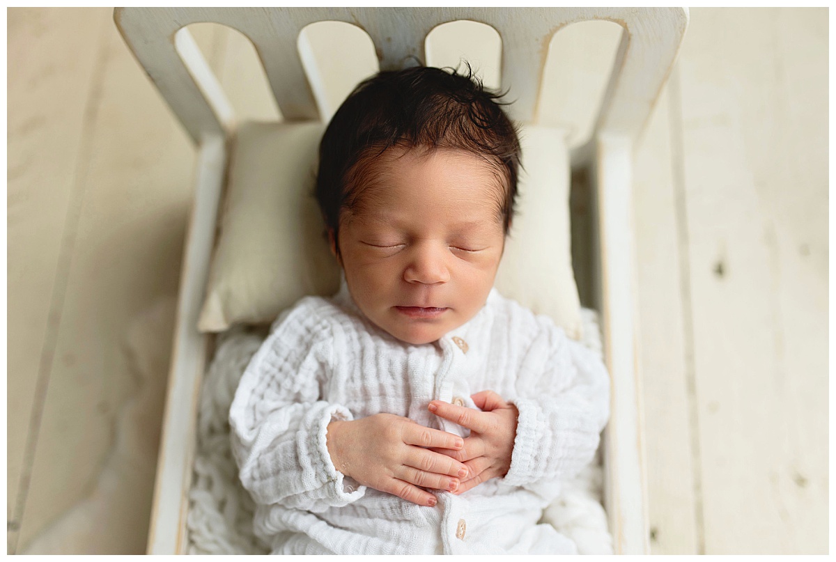 baby rests on tiny bed by Amy Yang Photography