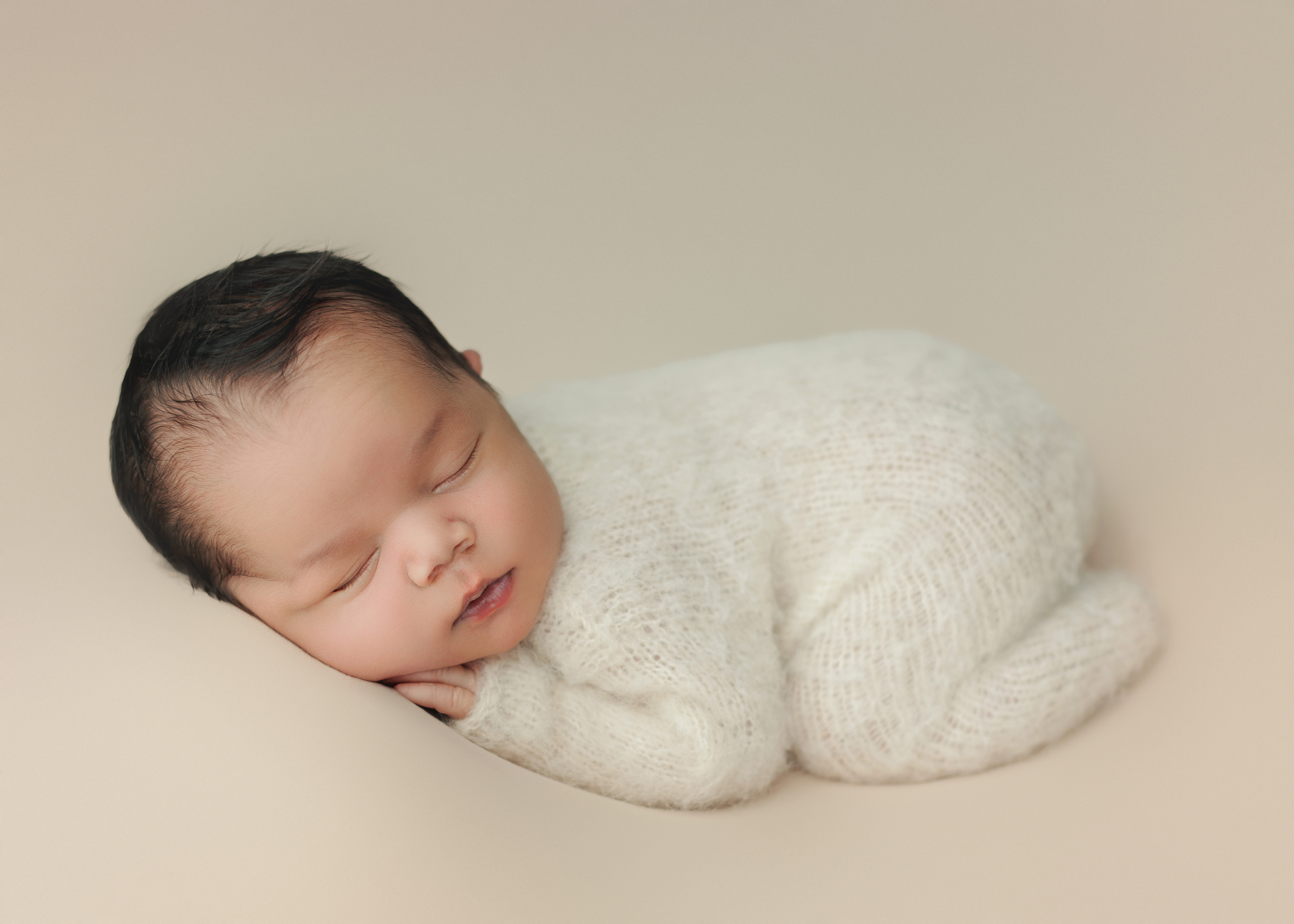 Newborn baby boy in white fuzzy pjs