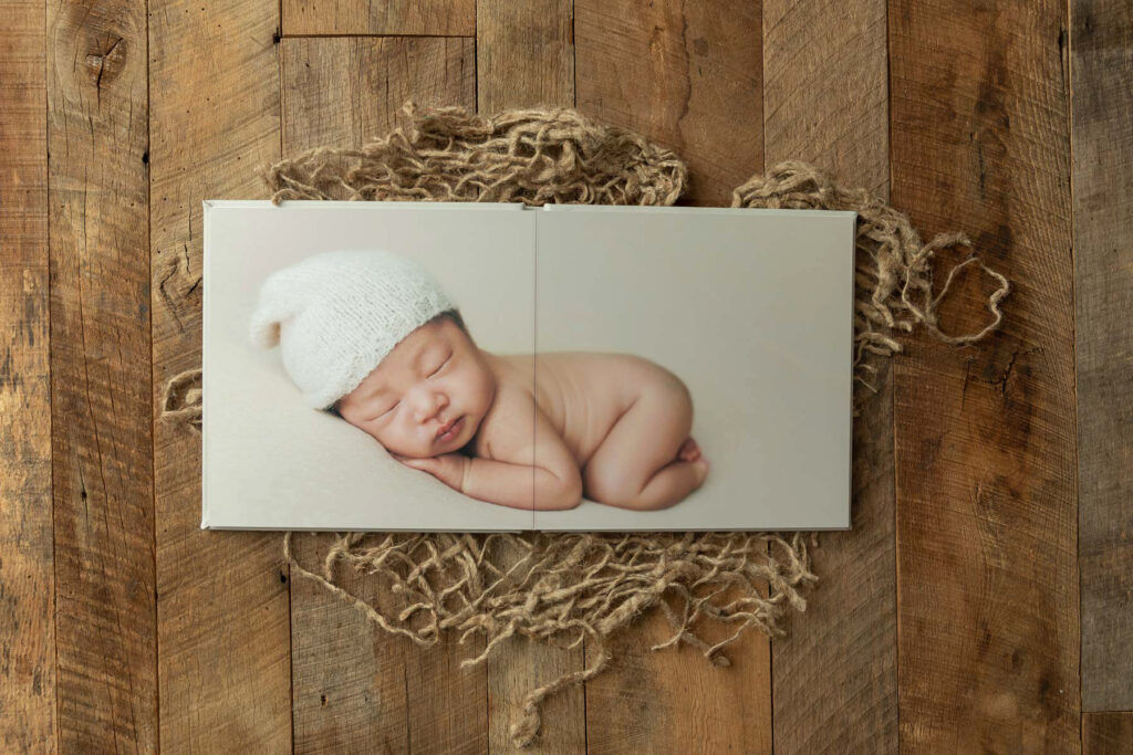 Custom newborn photo album featuring a sleeping baby portrait during Charlottesville newborn session.