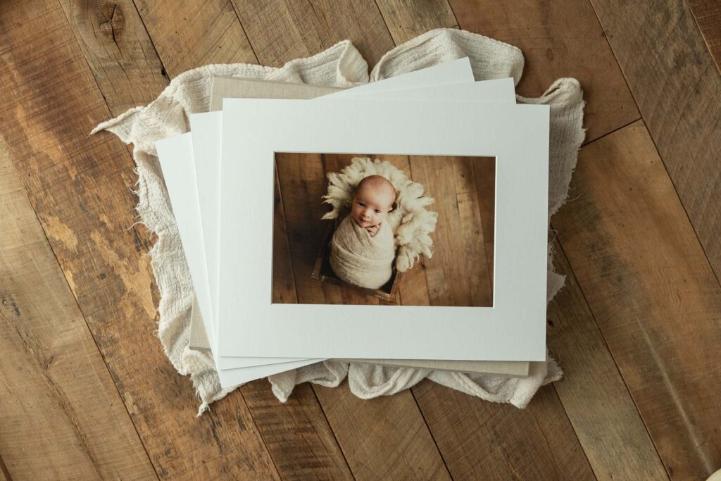 Fine art prints displayed from a newborn photo album by Charlottesville newborn photographer.
