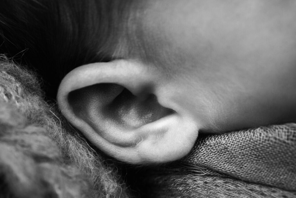Close-up of a newborn's tiny ear highlighting the beautiful details preserved through heirloom newborn photography.