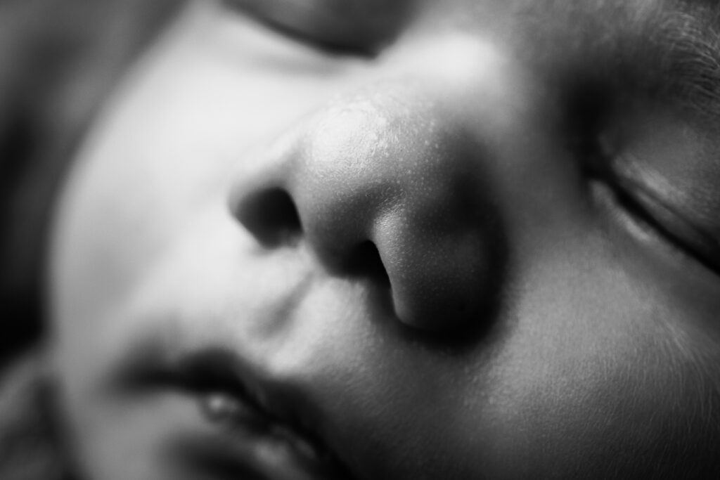 Macro portrait of a newborn's tiny nose capturing the fine details that make heirloom newborn photography so meaningful.
