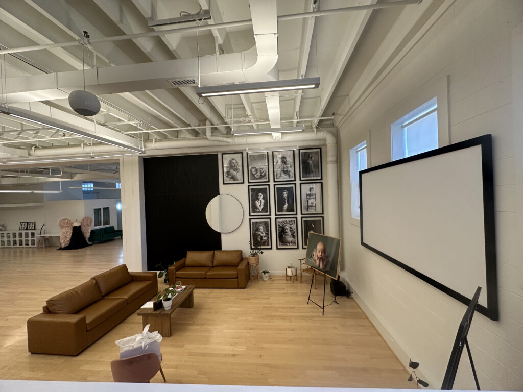 Welcoming newborn photography studio with client viewing area and wall art display. Amy Yang Photography studio in Charlottesville, VA.