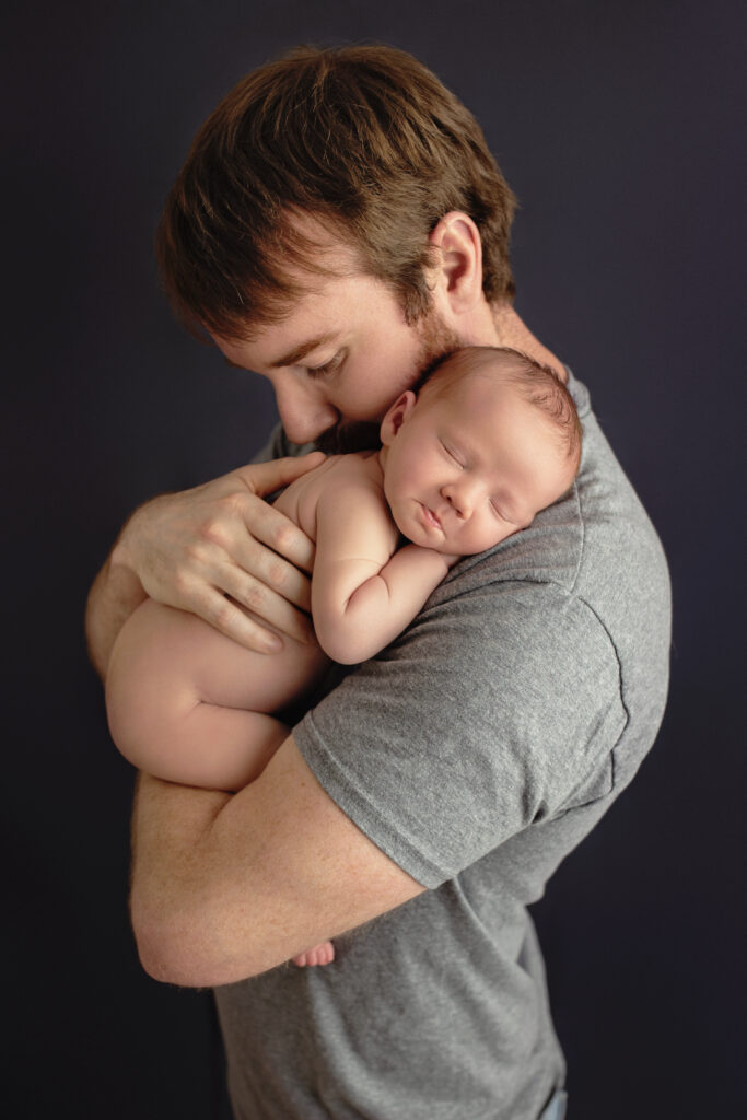 Parents gently holding their sleeping baby during a newborn session with Amy Yang Photography at Richmond, VA.