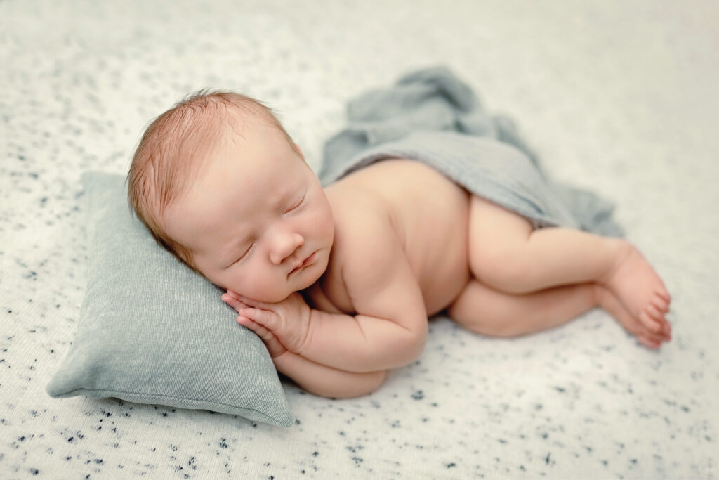 Sleeping newborn resting on a soft pillow, during a newborn session with Amy Yang Photography at Richmond, VA.