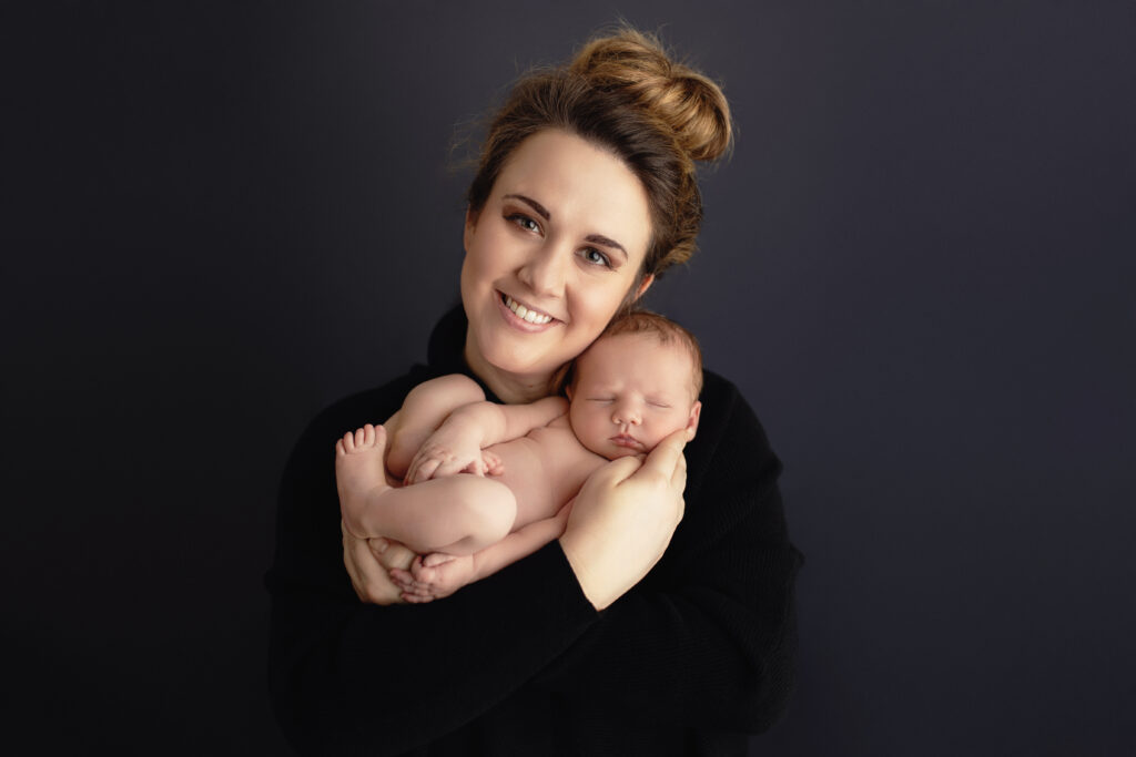 Mother cuddling her sleeping baby, highlighting what actually happens during a 2-4 hour newborn session with family portraits in Charlottesville, VA.