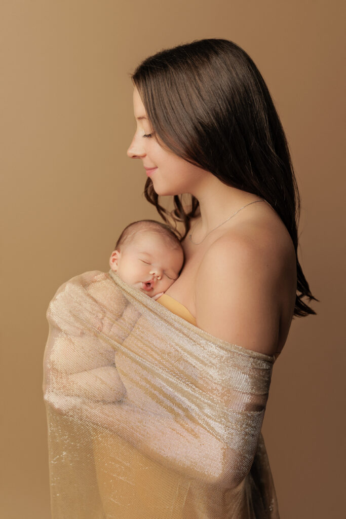 Mother holding her sleeping newborn during a Charlottesville newborn session.