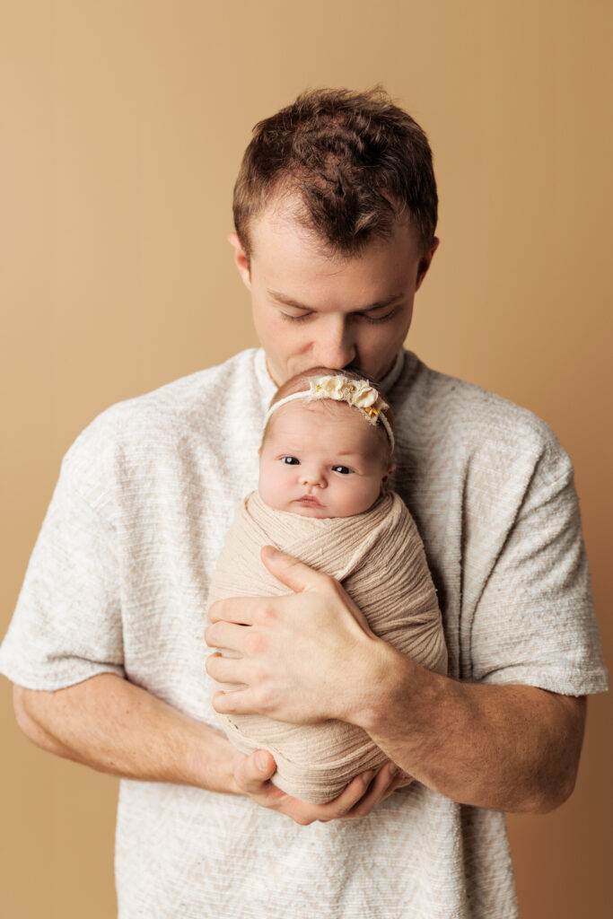 Father holding his newborn baby during a Charlottesville newborn photography session.